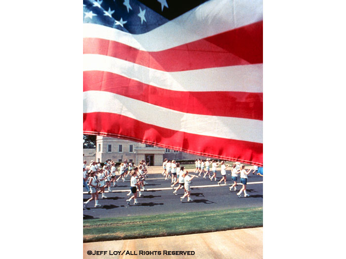A marching band comprised of students from Paris and North Lamar High Schools pass an American flag during the annual Celebrate America Fourth of July parade in downtown Paris, Texas.