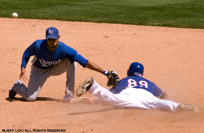Not realizing he bobbled the catch, Kansas City Royals shortstop Tony Pena tries to tag Texas Rangers center fielder Craig Gentry.