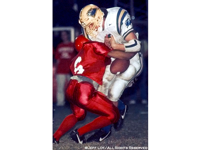 North Lamar High School quarterback Scott Moffitt drops the ball as he's sacked by Greenville High defensive back Marcus Anders.